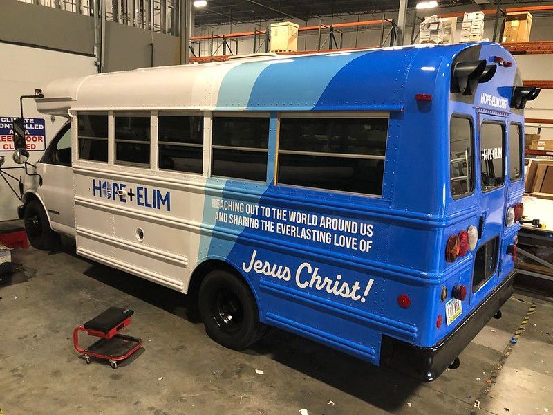 A white and blue bus parked indoors with the words 