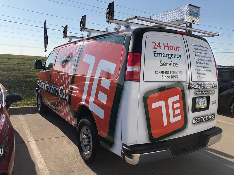 A white Tri-City Electric Co. work van with large red and white branding parked in an outdoor lot.