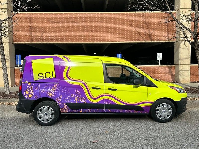 A lime green and purple van with a logo saying 