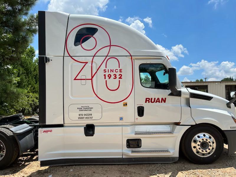 A white Ruan semi-truck parked outdoors, featuring a large red 