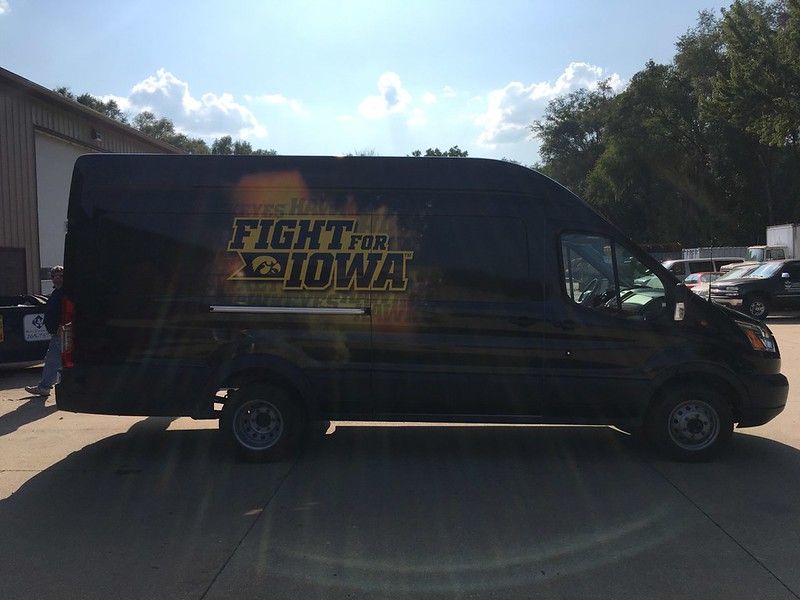 A black van parked on pavement, featuring 