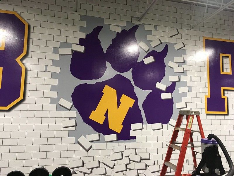 A purple and yellow paw print logo with an 