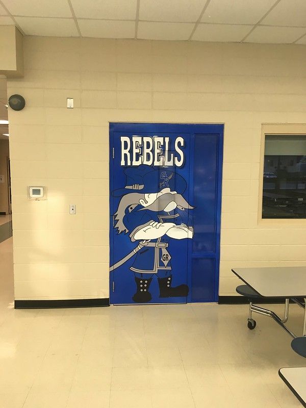 A blue door in a hallway features the word 
