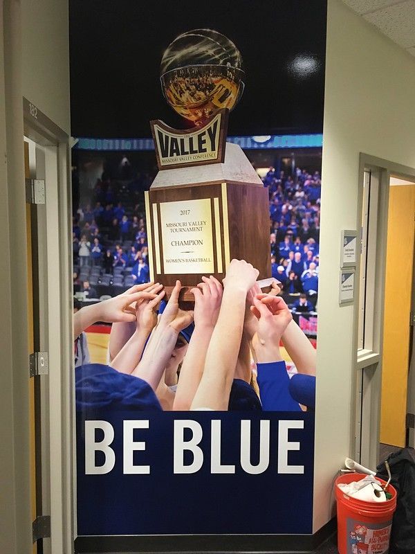 A wall graphic shows hands lifting a 