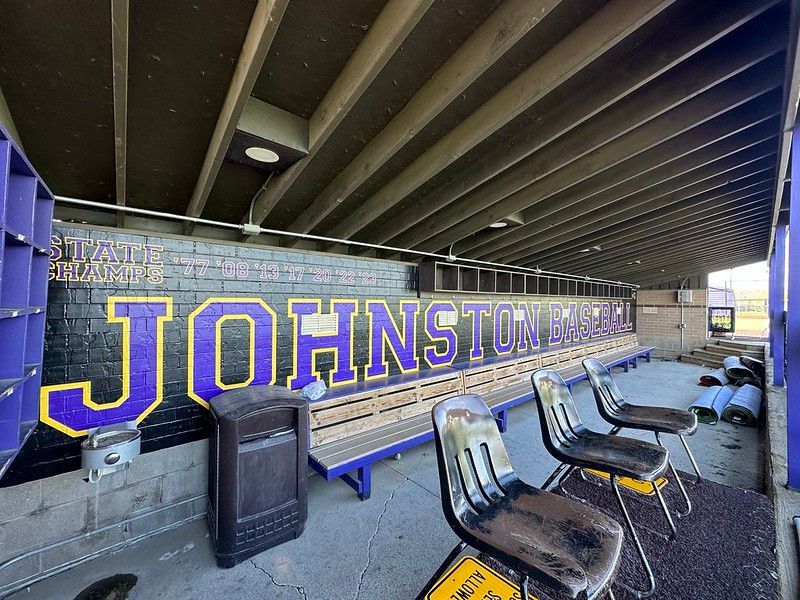 A baseball dugout with a black brick wall featuring 