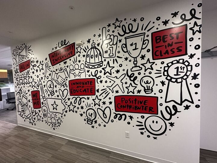 A wall mural featuring black-and-white doodles and red text boxes with encouraging phrases like 