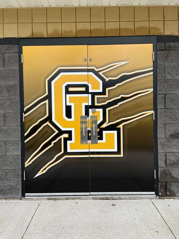 Double doors with a black and gold graphic of the letters 