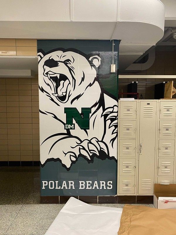 A mural of a snarling white polar bear with a green letter 