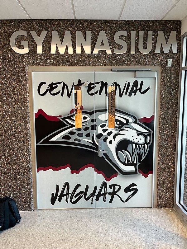 Gymnasium double doors featuring the Centennial Jaguars logo, a snarling jaguar head, in black, white, and maroon.