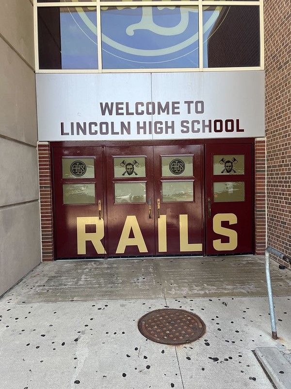 Entrance to Lincoln High School featuring maroon doors with gold 