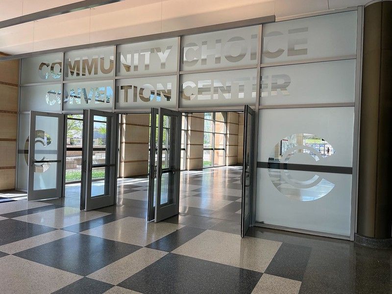 Glass entrance doors to the Community Choice Convention Center with checkerboard tile flooring.