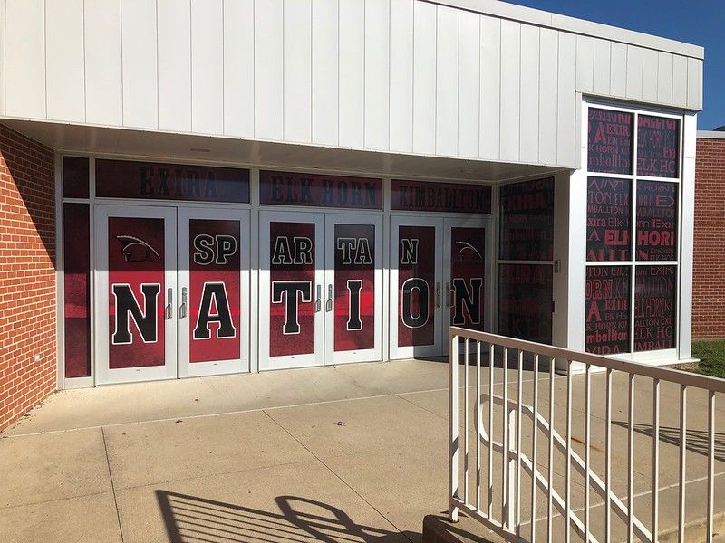 School building entrance with glass doors displaying the words 
