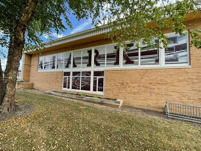 Brick building with large windows displaying the word 