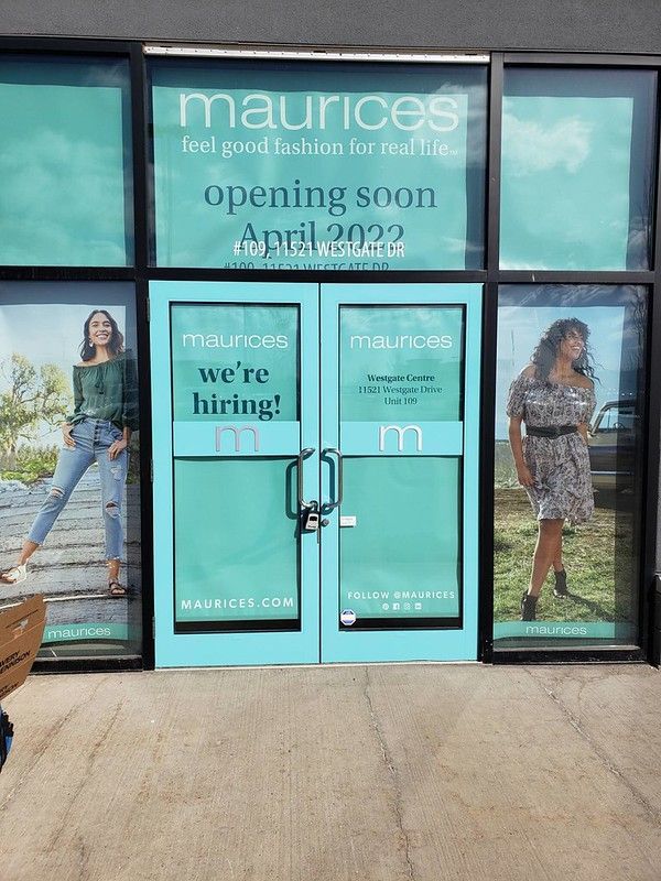 A Maurices store with teal window decals advertising a hiring sign and an April 2022 opening.
