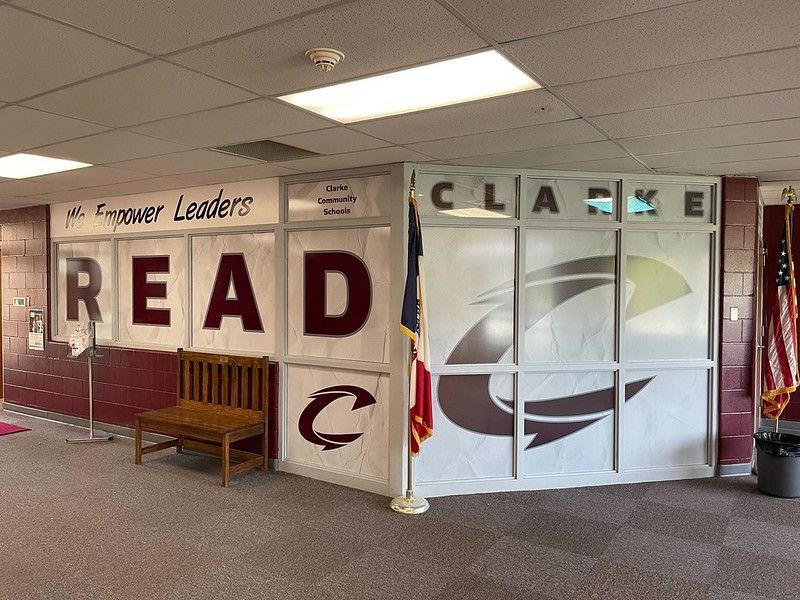 A maroon and white school hallway wall with 