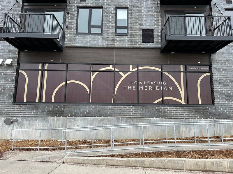 Brick building exterior with large window signage reading 