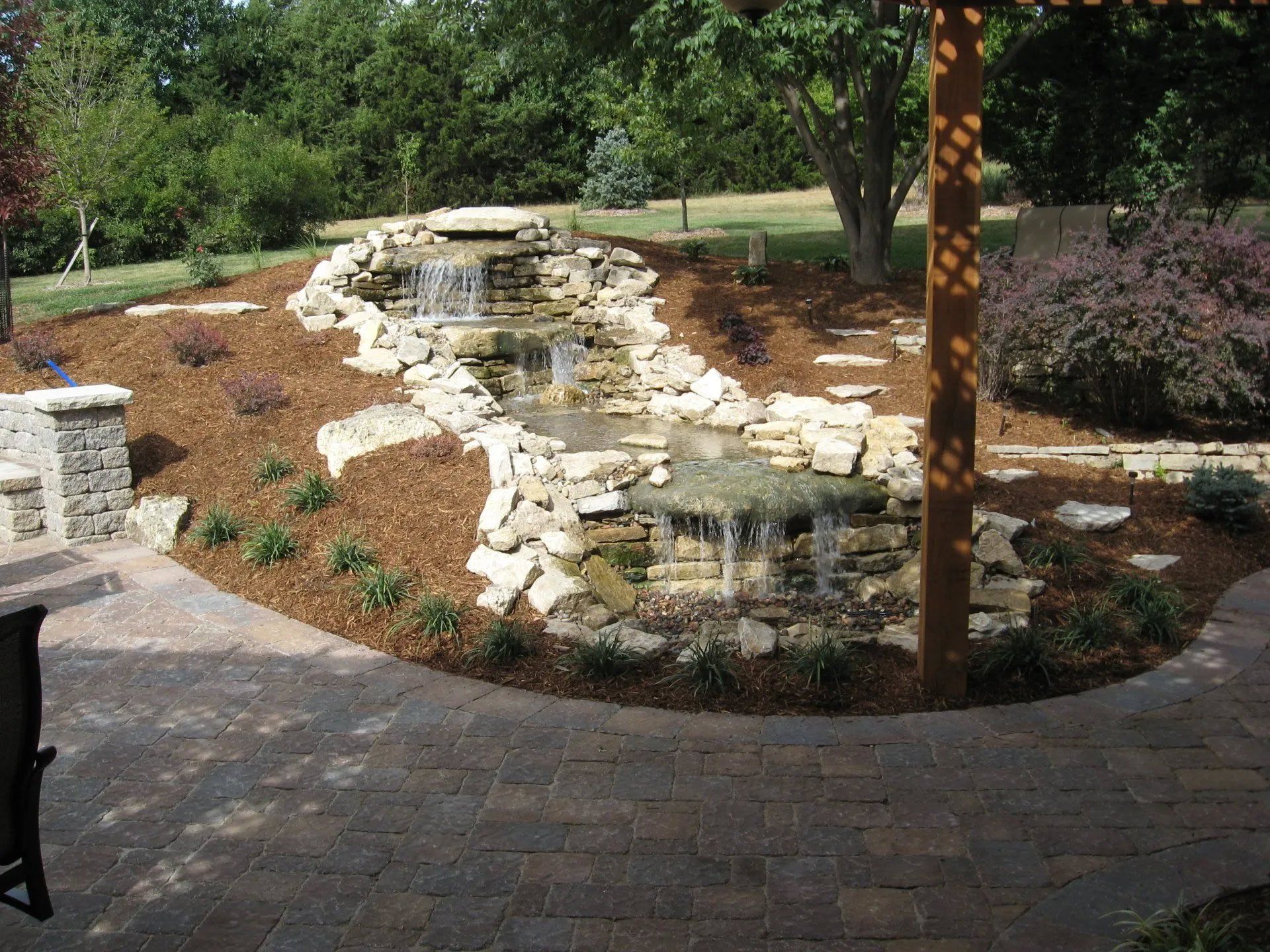 A waterfall is in the middle of a patio area