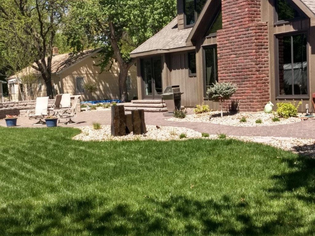 A large brick house with a large lawn in front of it