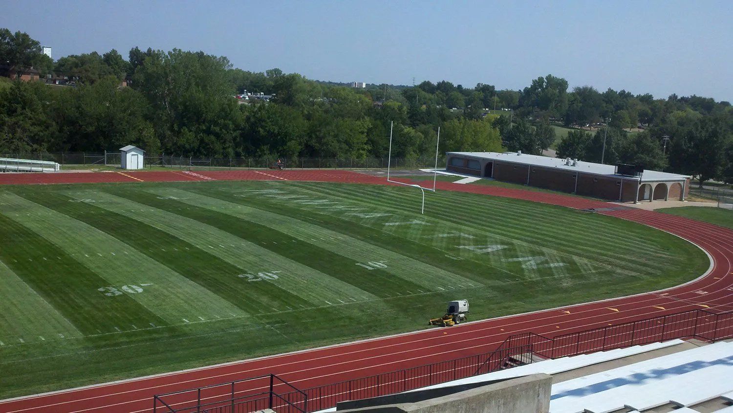 A soccer field with a track in the background