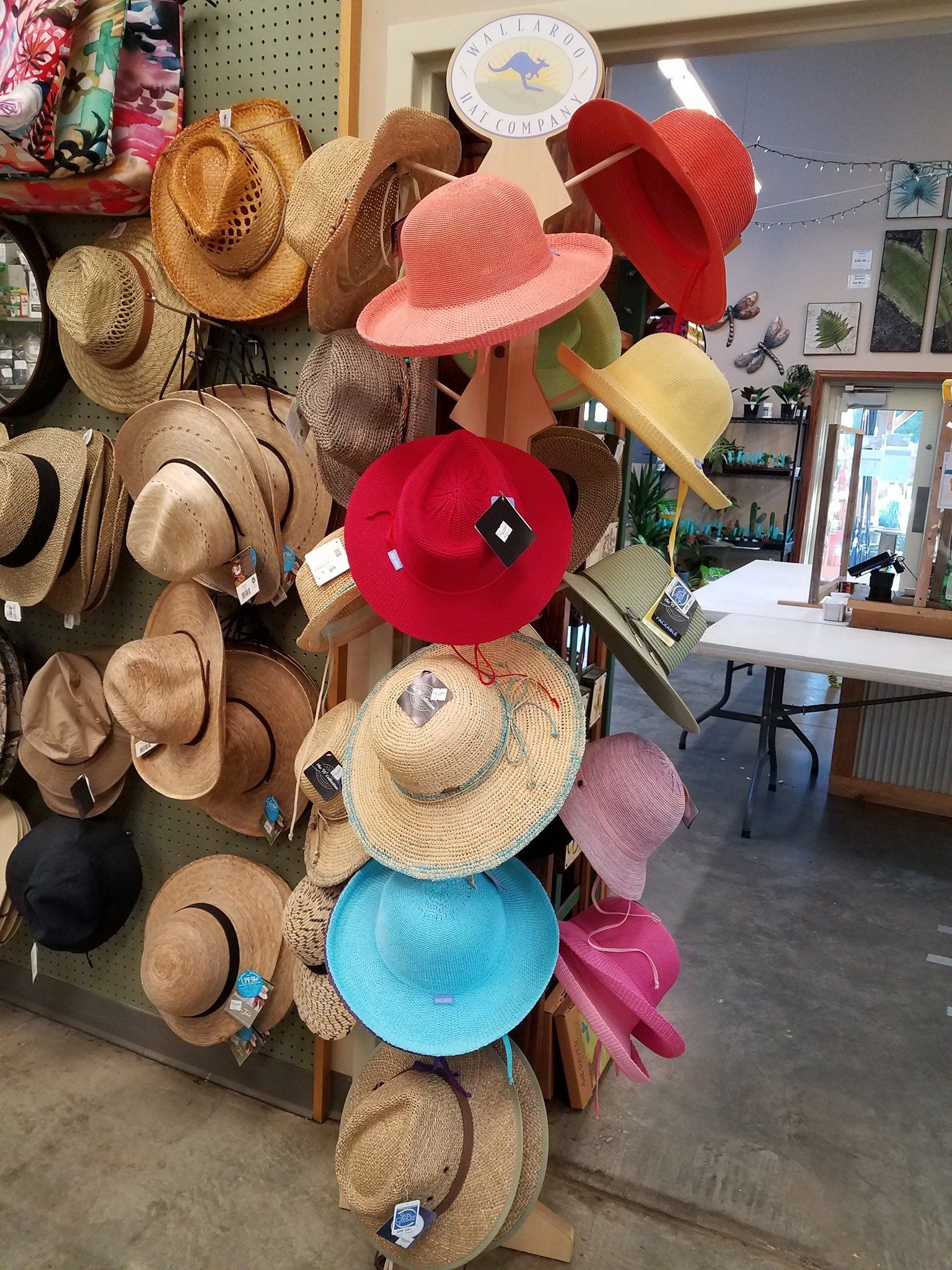 A bunch of hats are hanging on a rack in a store.