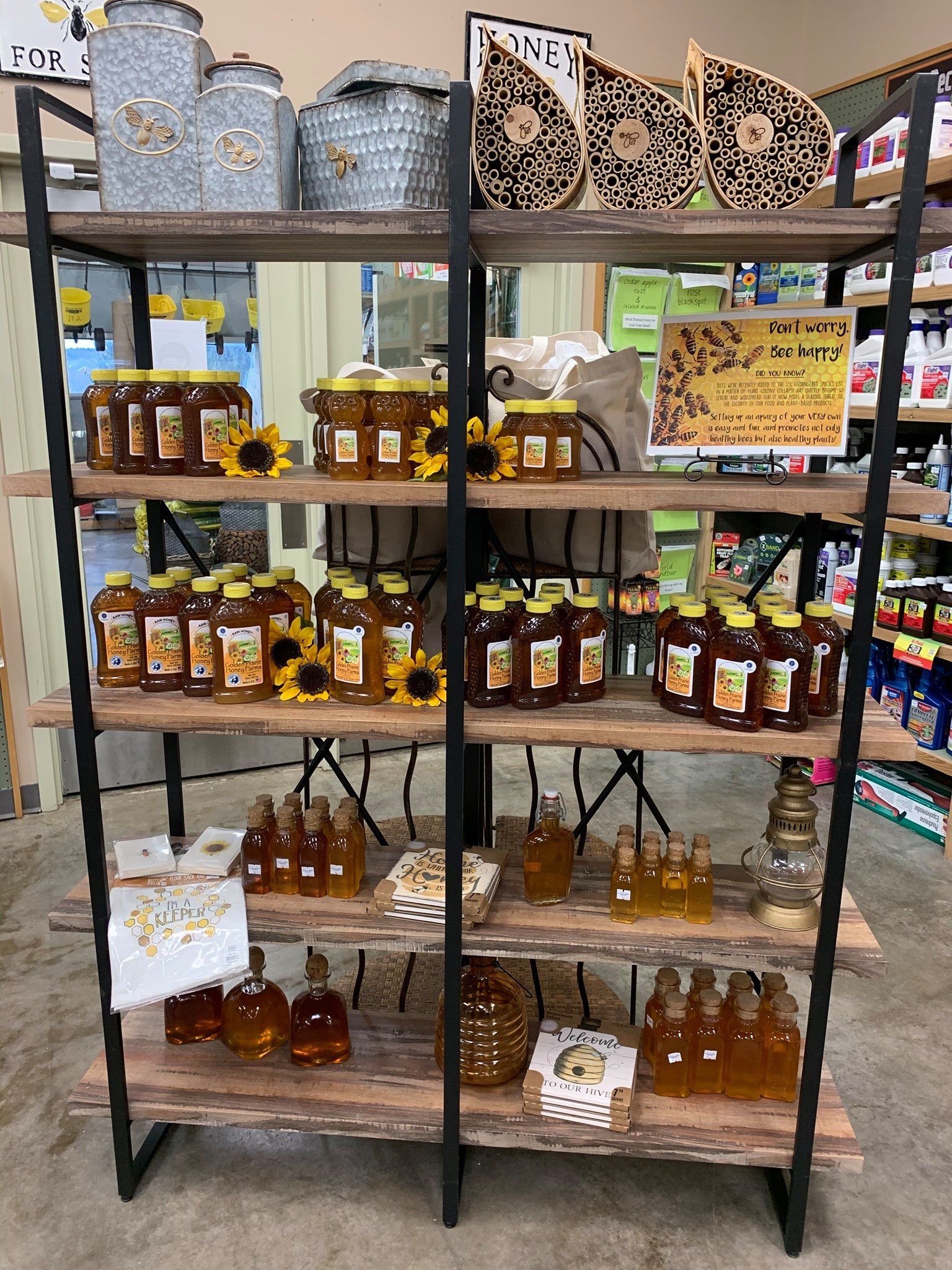 A shelf filled with jars of honey and sunflowers in a store.