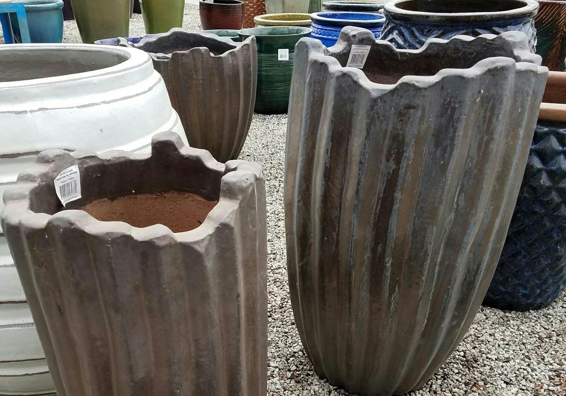 A group of pots are sitting on a gravel surface.