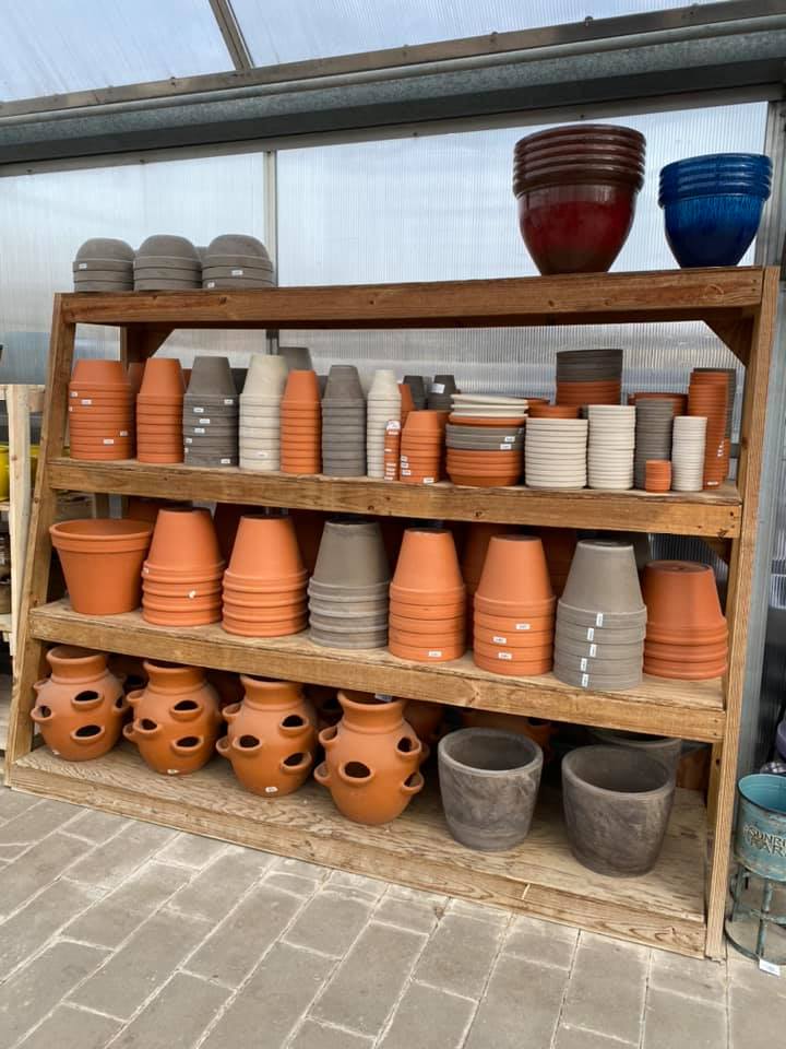 A wooden shelf filled with lots of pots and bowls