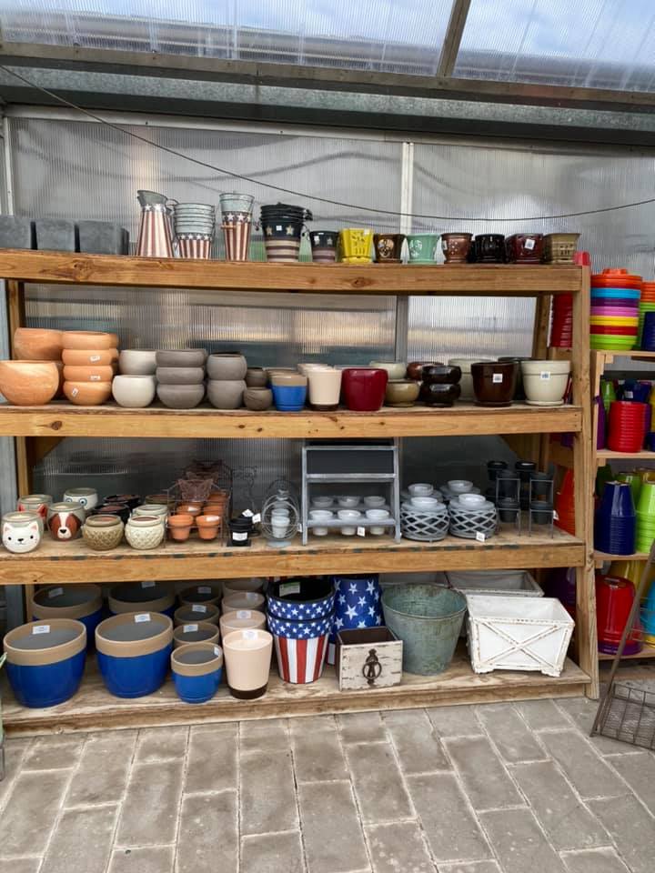 A wooden shelf filled with lots of pots and bowls.