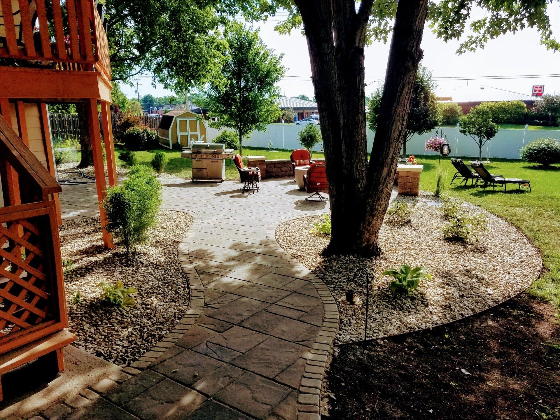 A patio with a fire pit and chairs surrounded by trees
