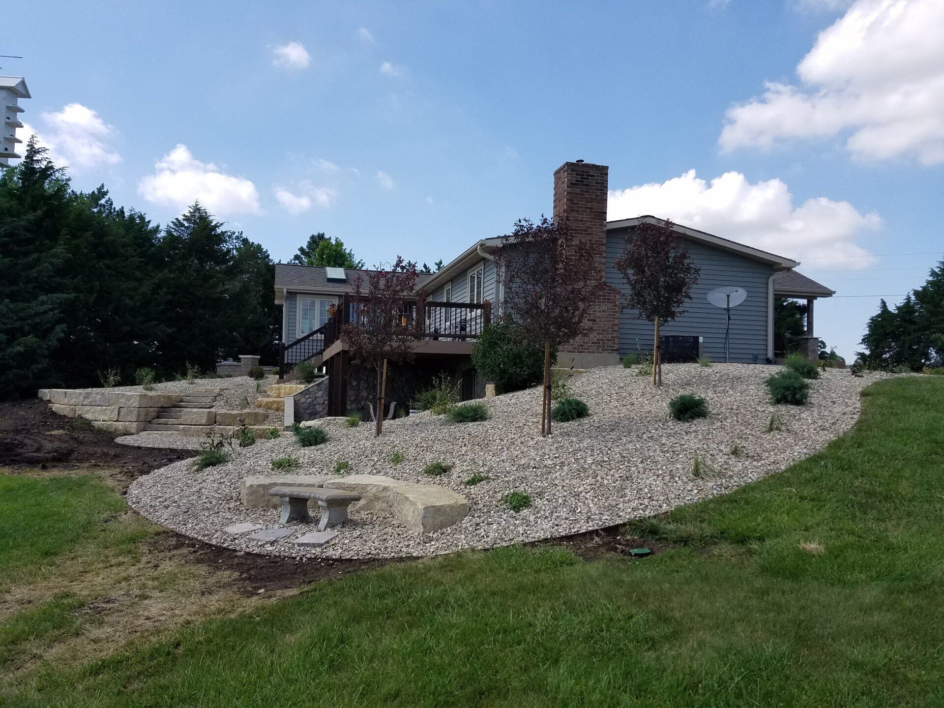 A house with a deck and a fire pit in front of it