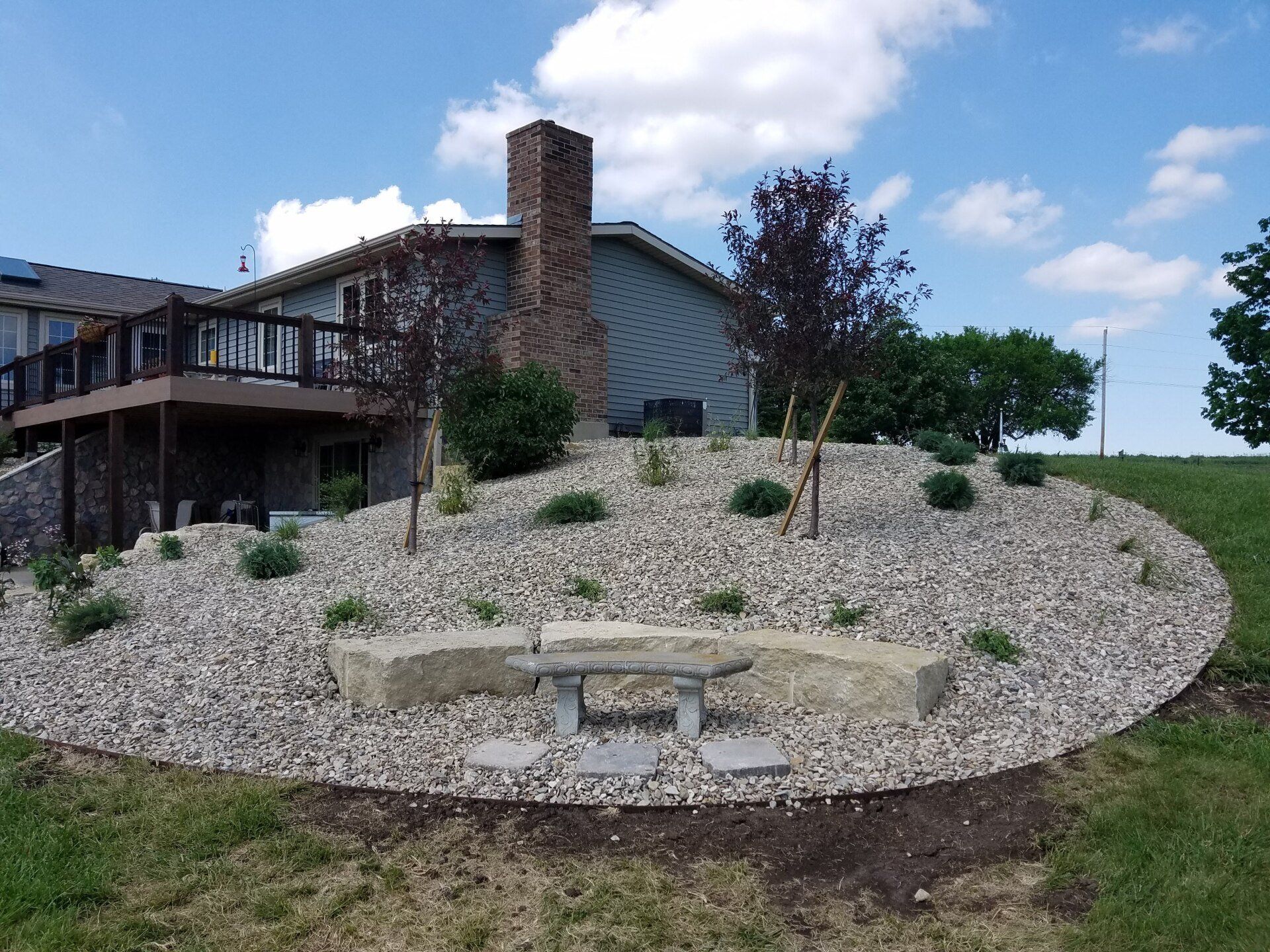 A house with a deck and a fire pit in front of it