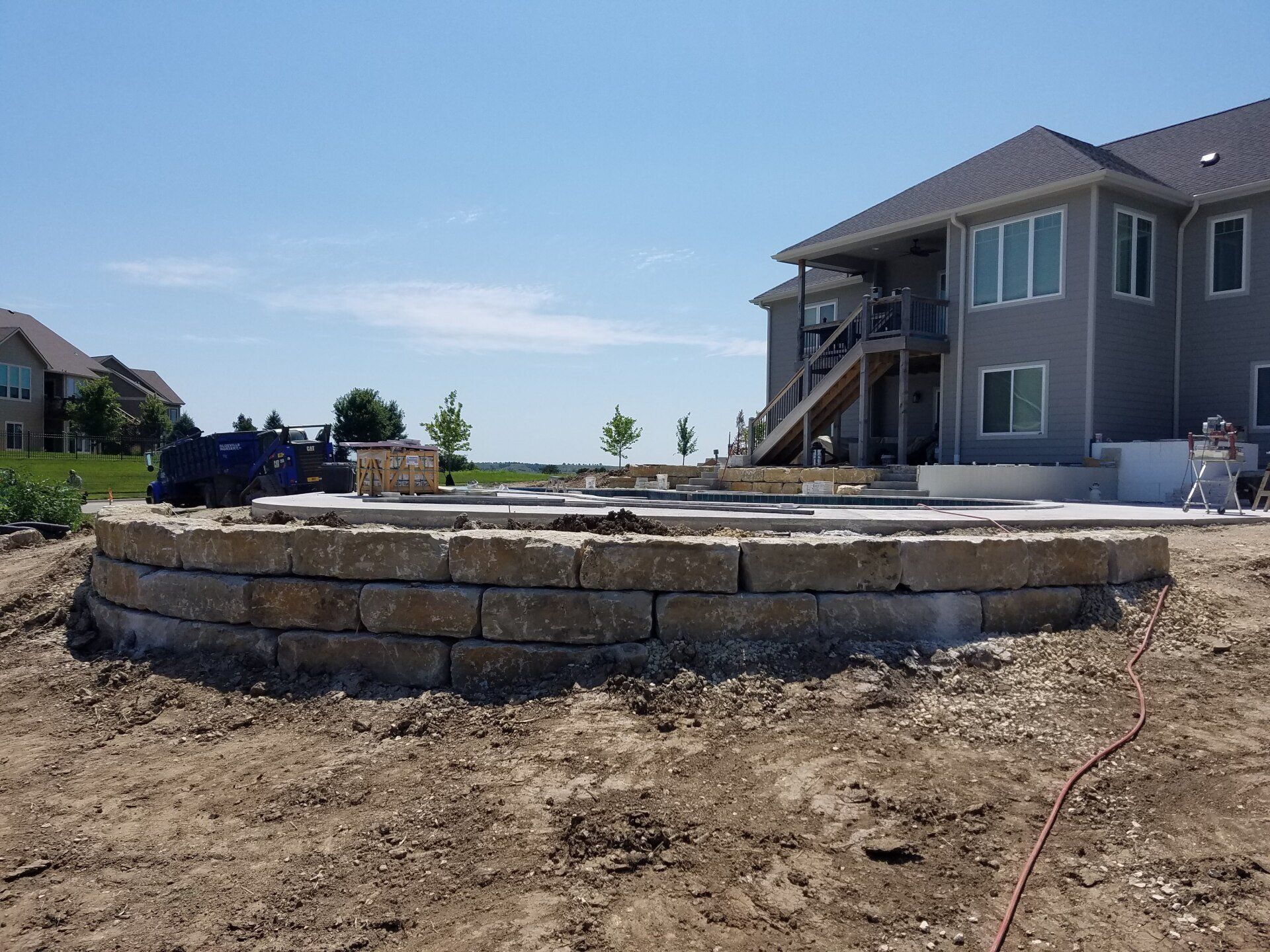 A large house is being built in the middle of a dirt field