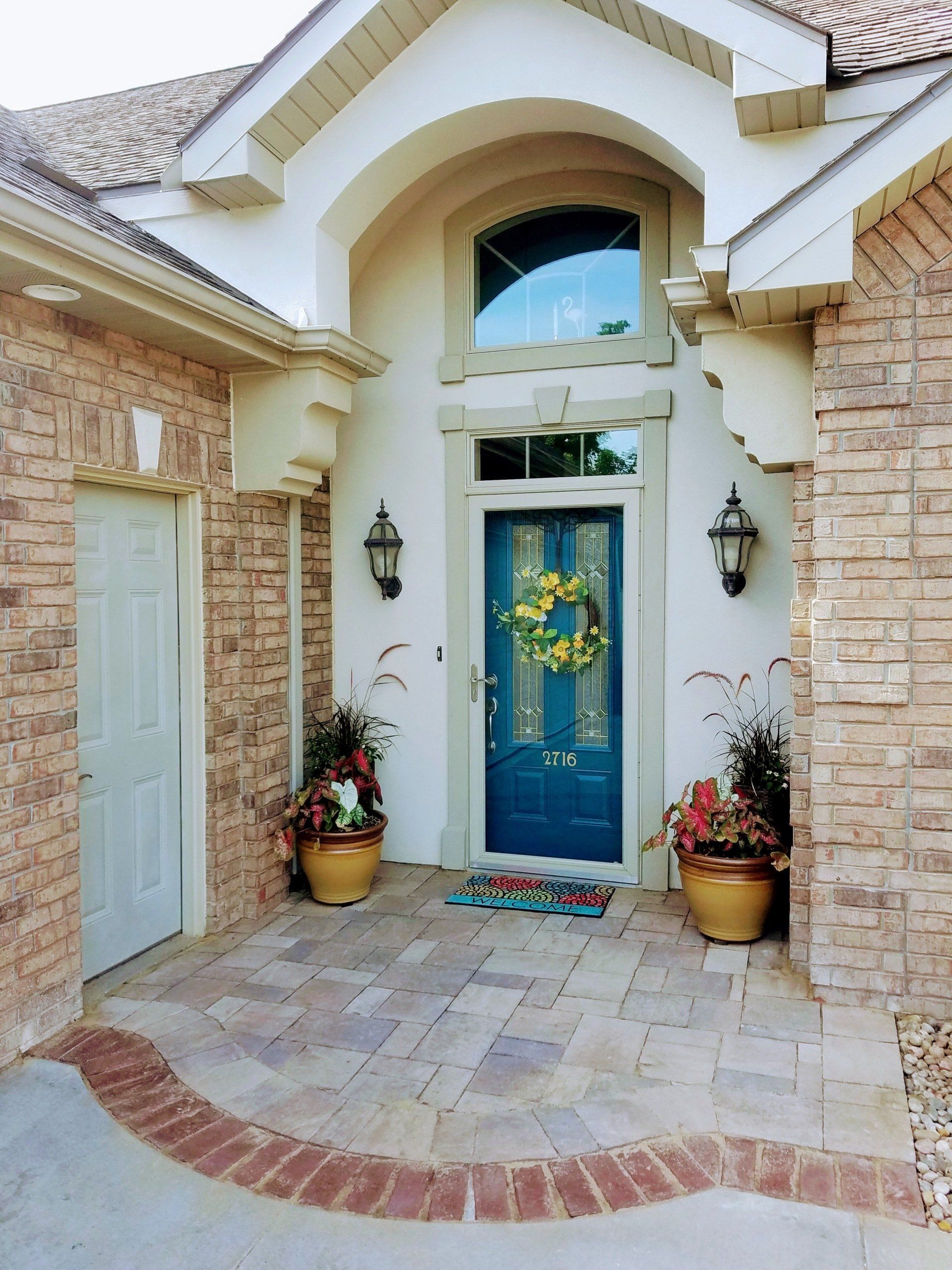 The front door of a brick house with a blue door