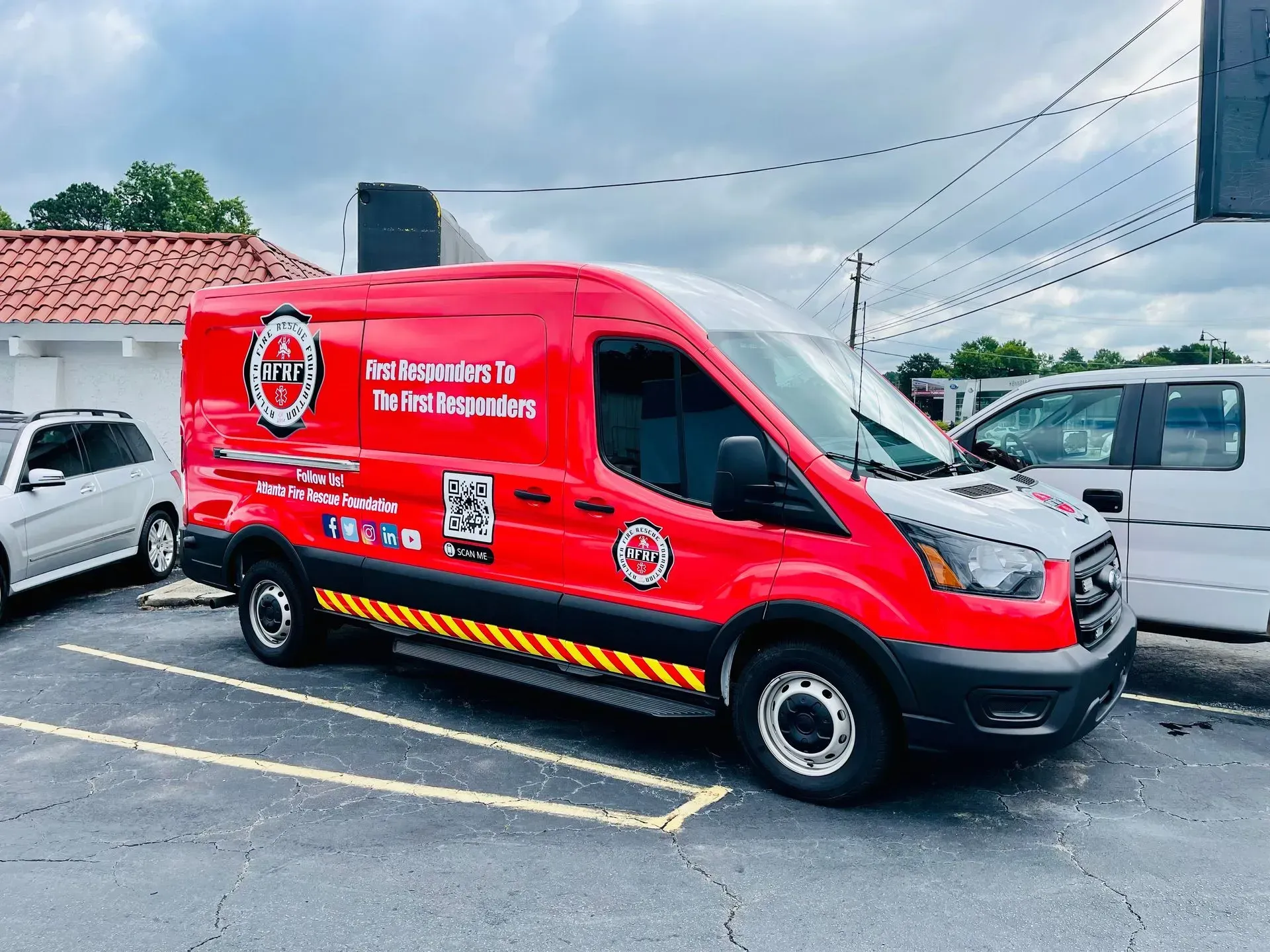 Red service van parked in a lot, with logo and text for first responders.