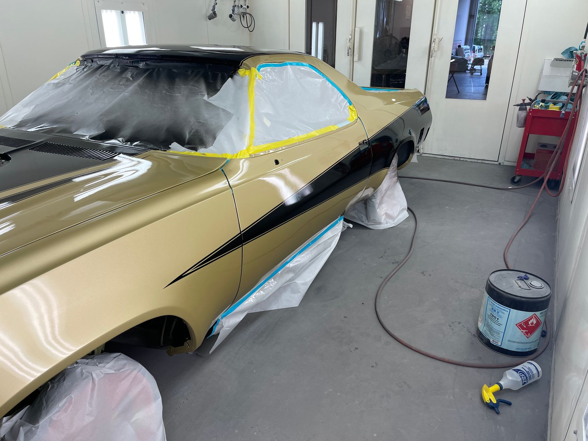 A car is being painted in a paint booth