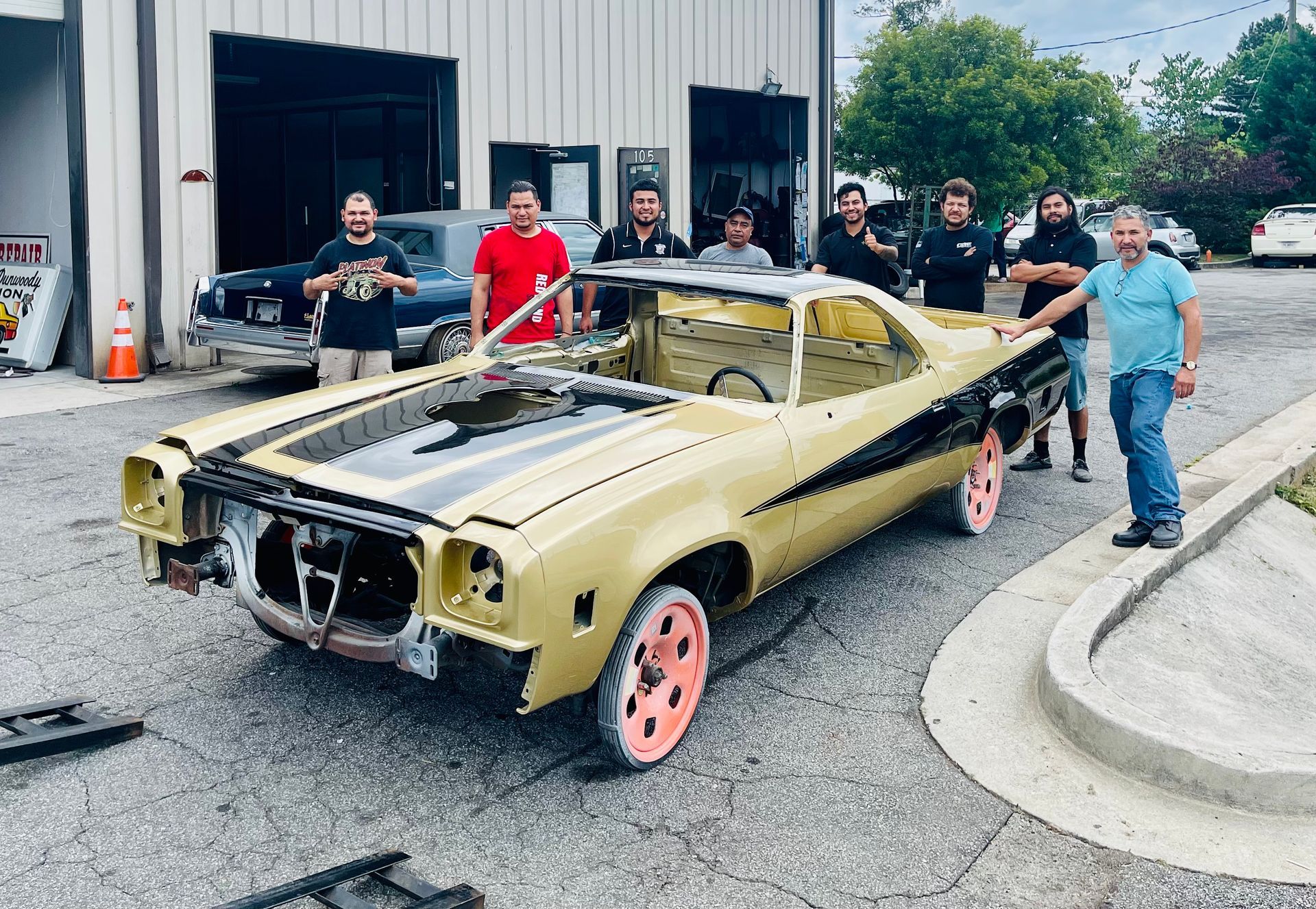 A group of men is standing around a good-looking car.