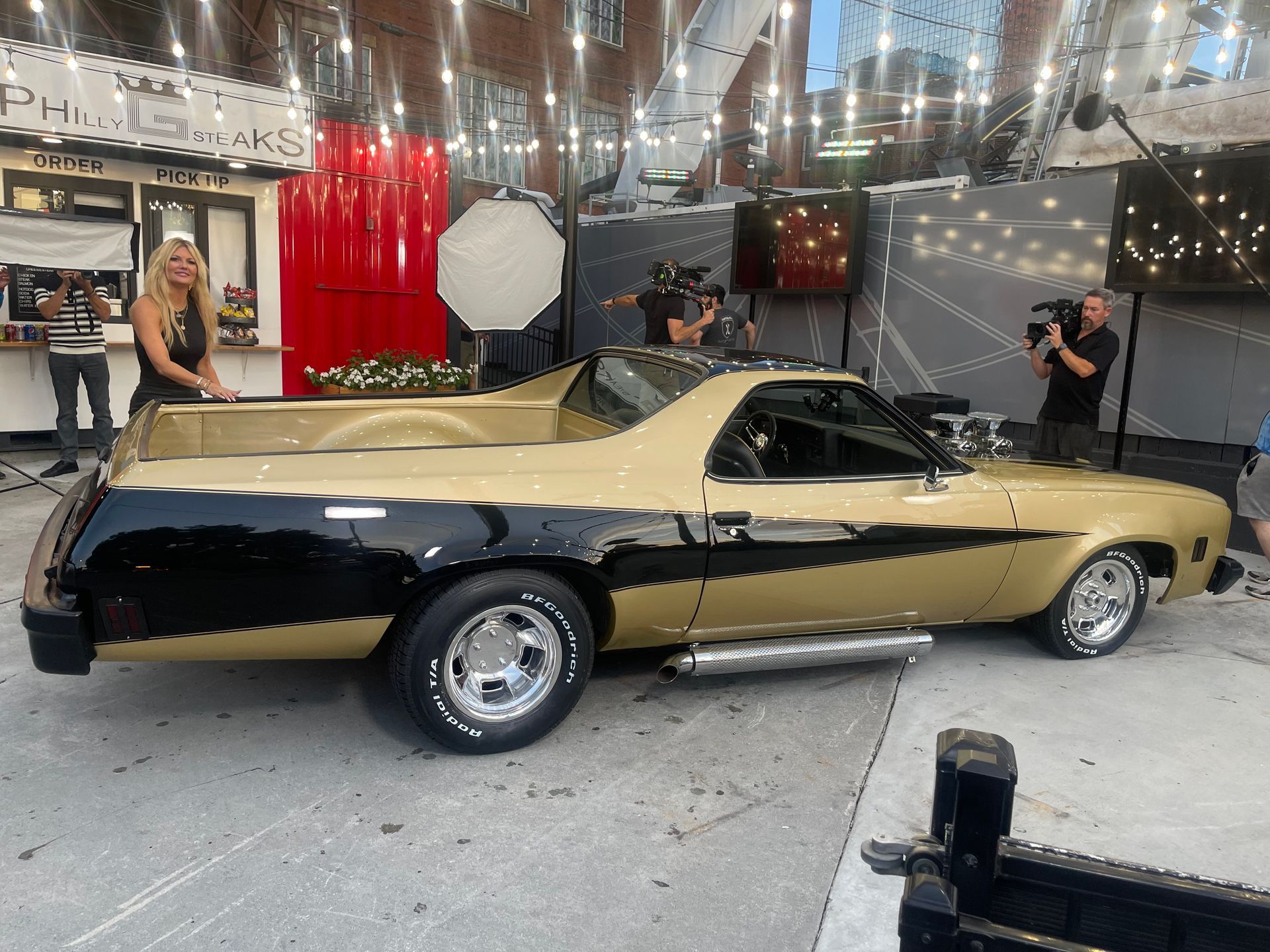 A black and gold car is parked in a parking lot