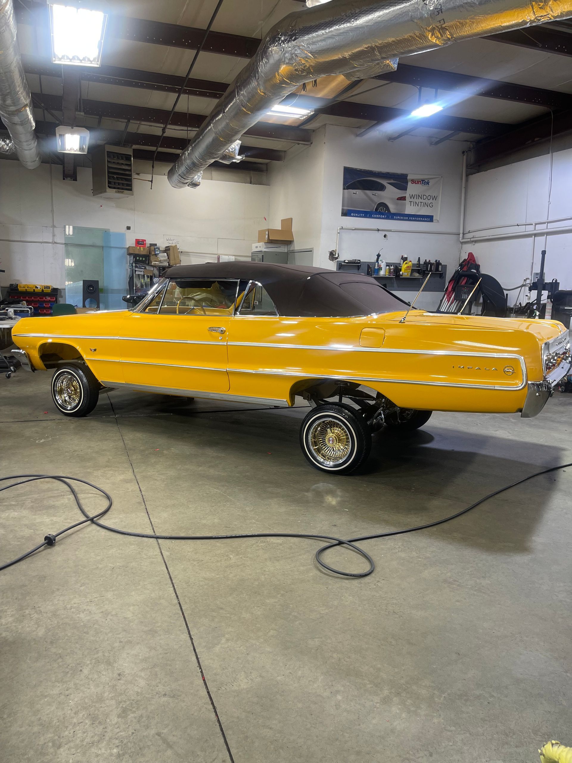 A yellow car is parked in a garage.