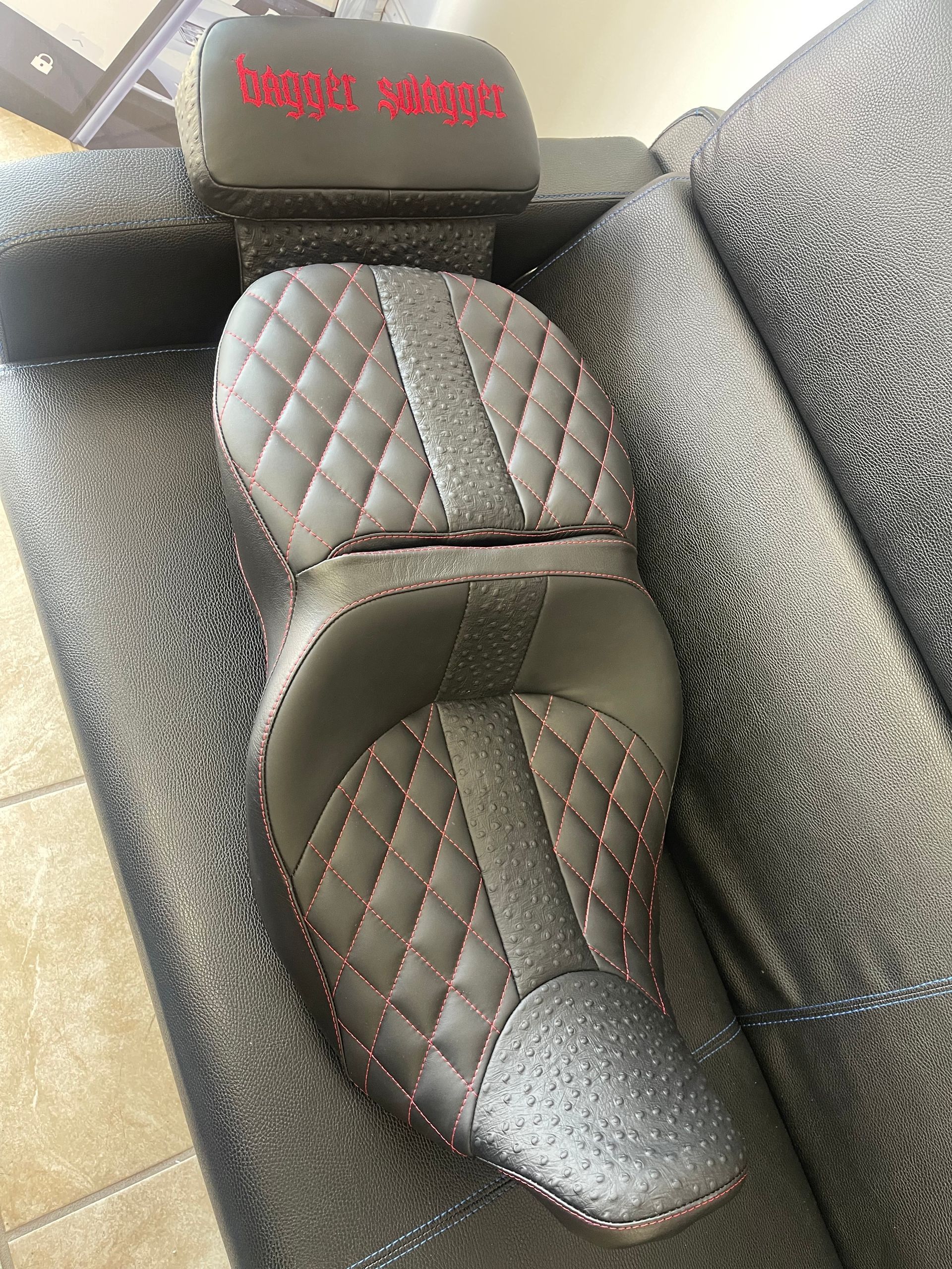 A motorcycle seat is sitting on top of a couch.