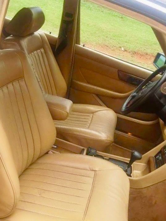The interior of a car with tan leather seats and a steering wheel.
