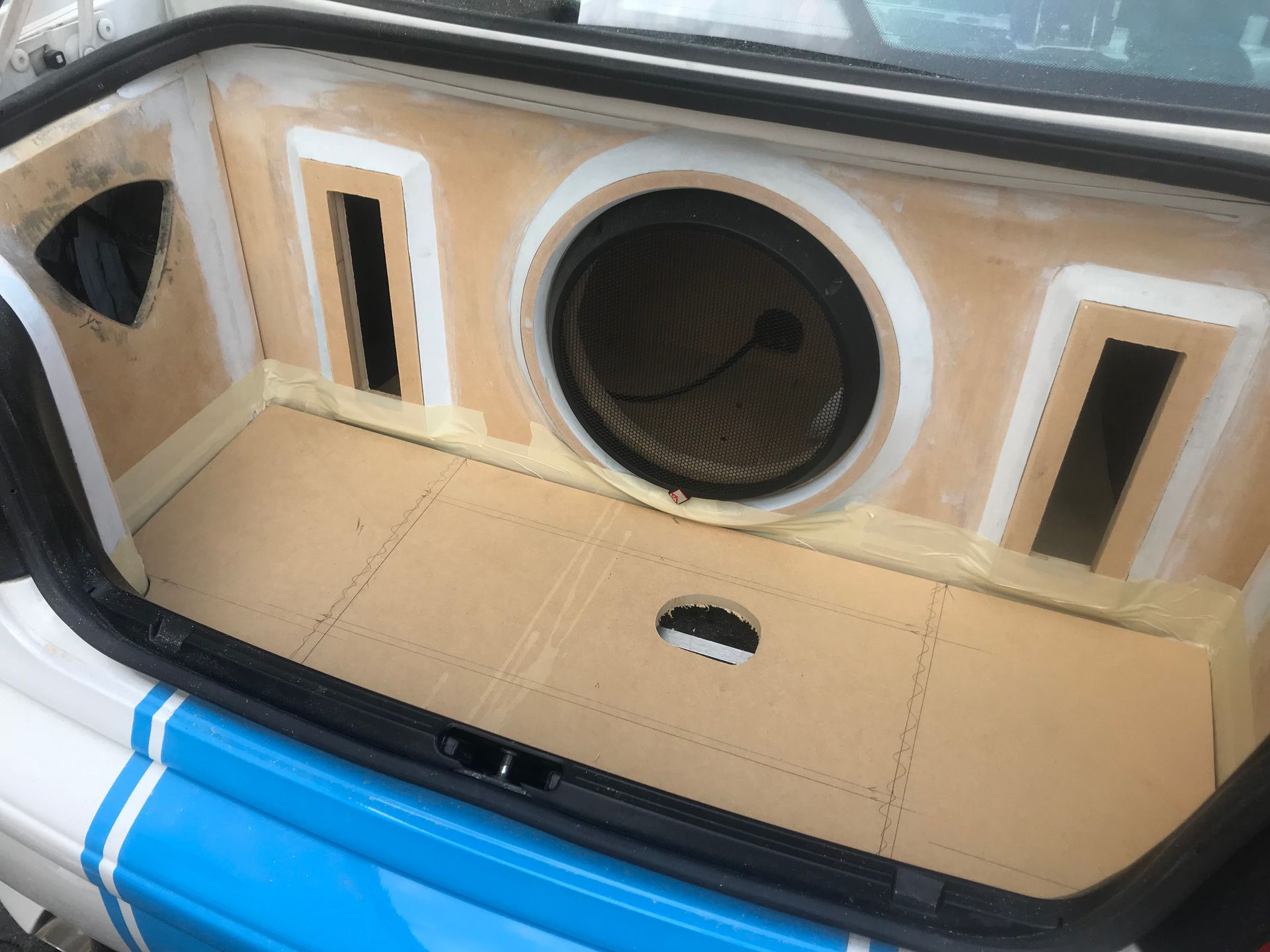 The trunk of a car with a subwoofer in it