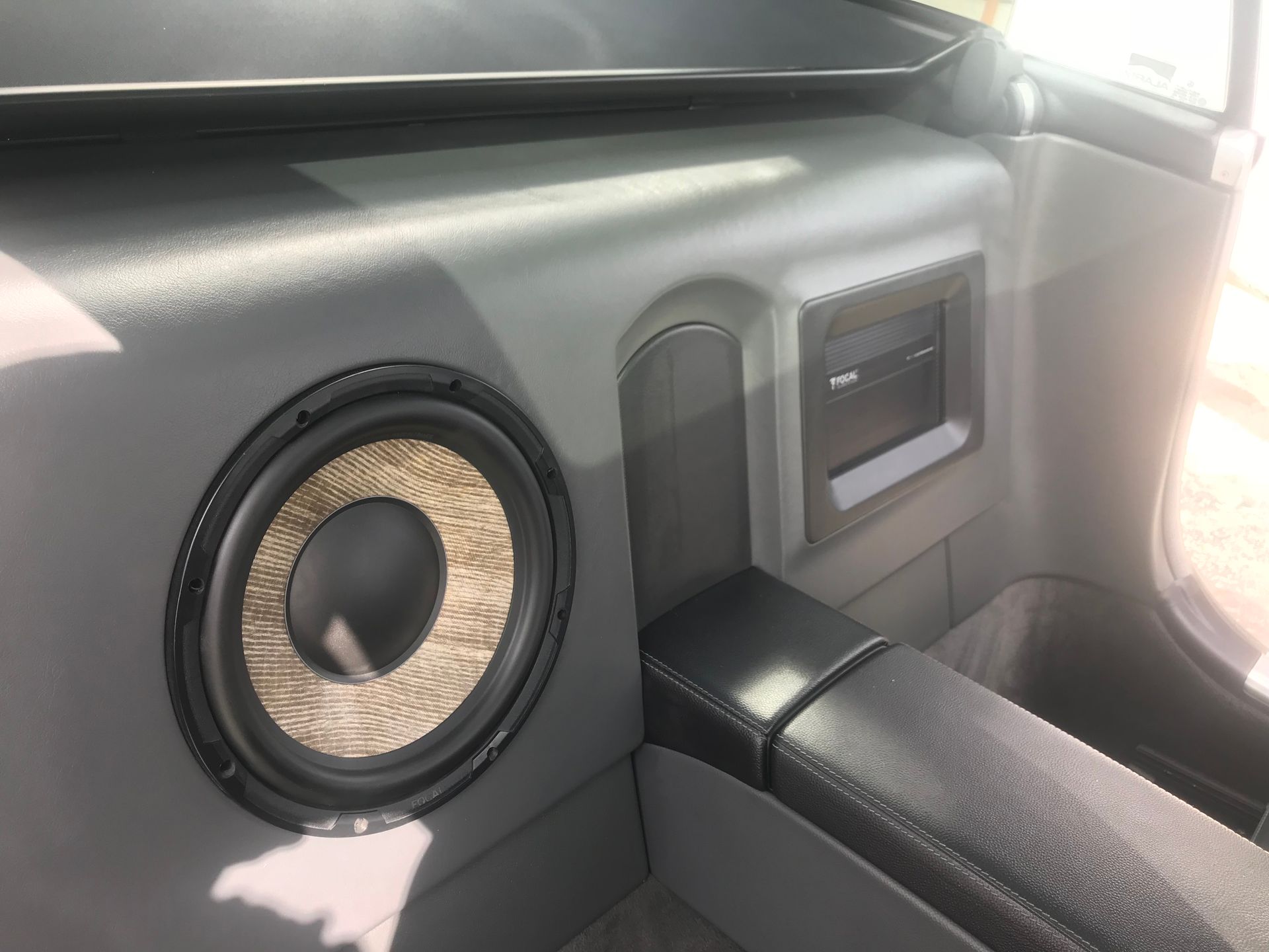 A subwoofer is sitting in the corner of a car