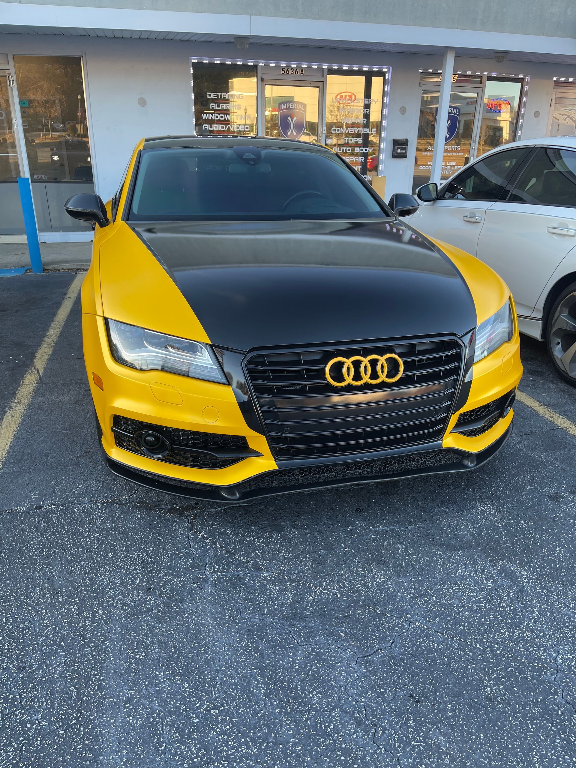 A black and yellow Audi A7 is parked in a parking lot.