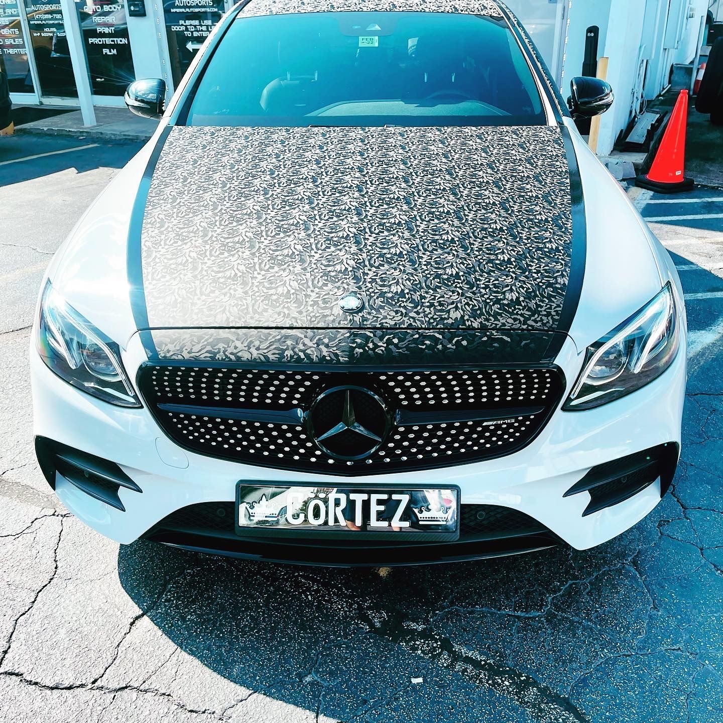 A white Mercedes with a license plate that says Cortez