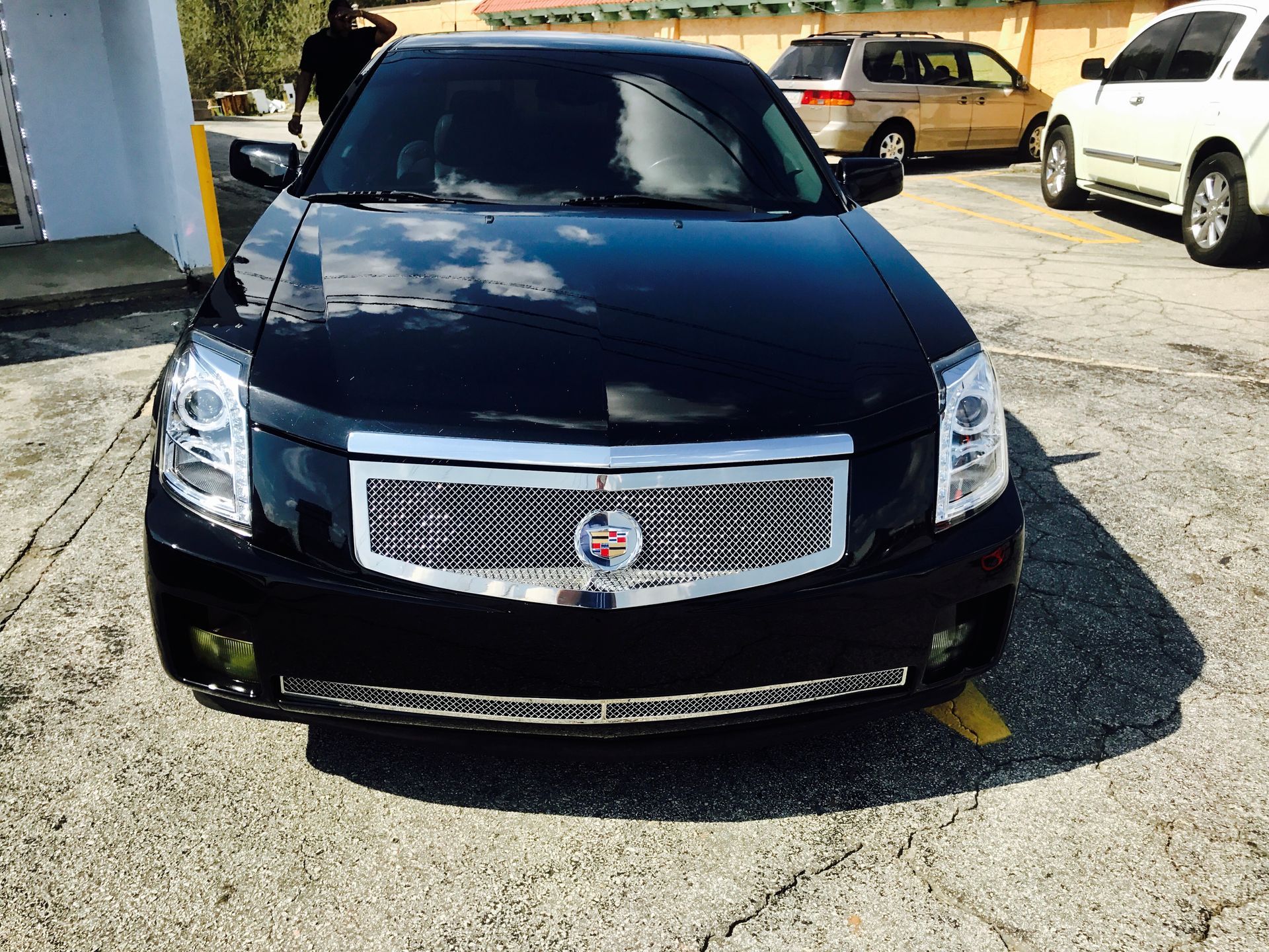 A black Cadillac is parked in a parking lot