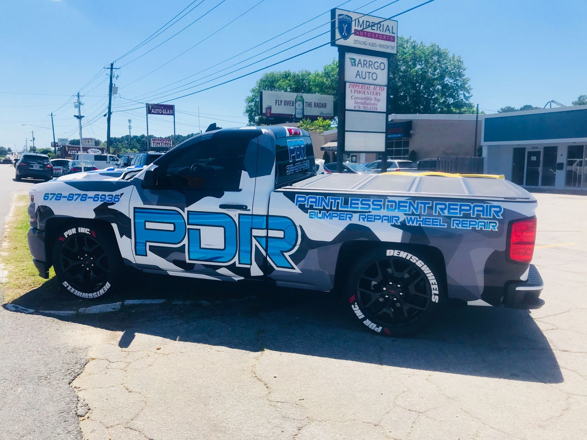 A truck with the word PDR on it is parked on the side of the road.