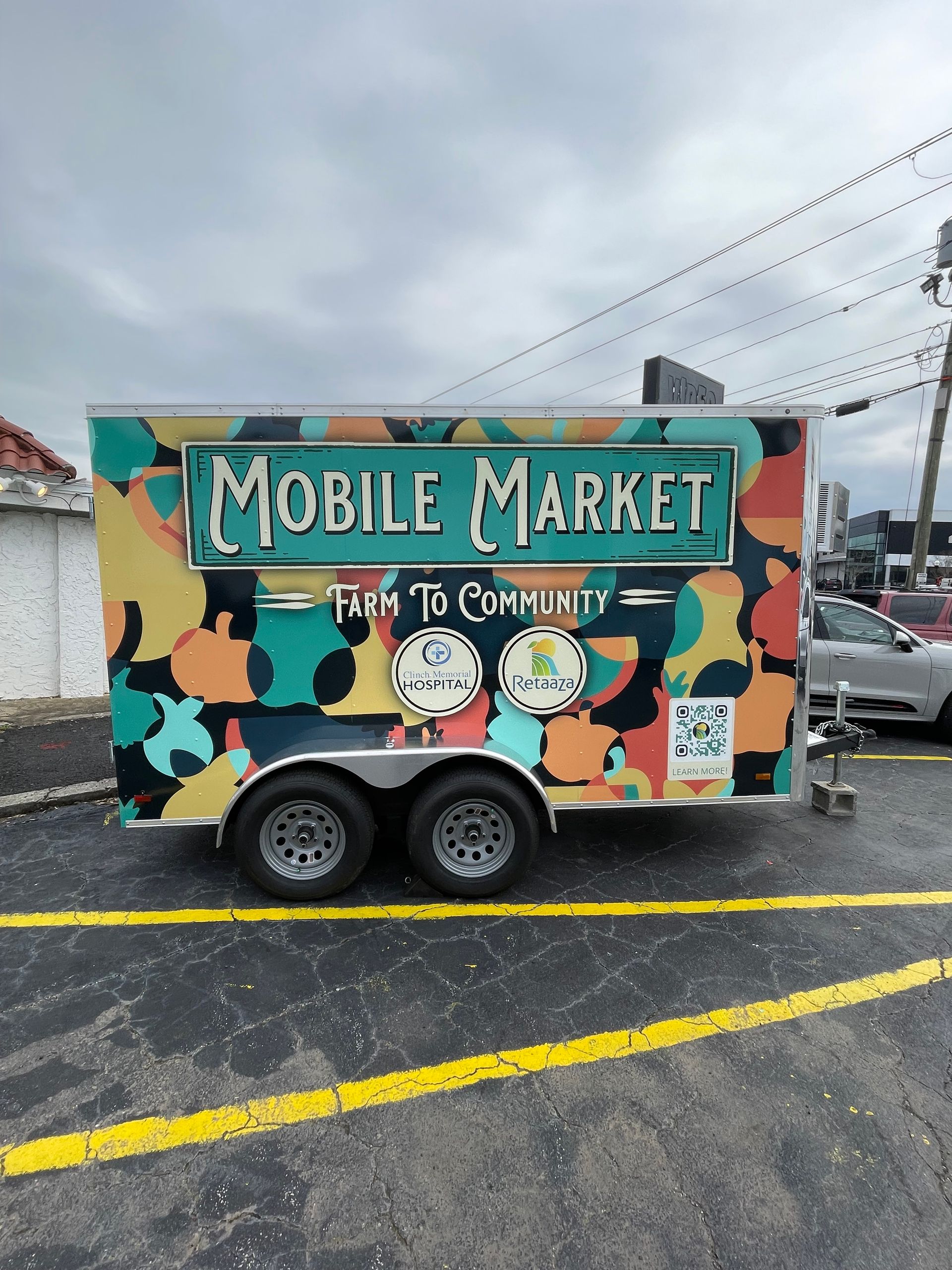 A mobile market trailer is parked in a parking lot.
