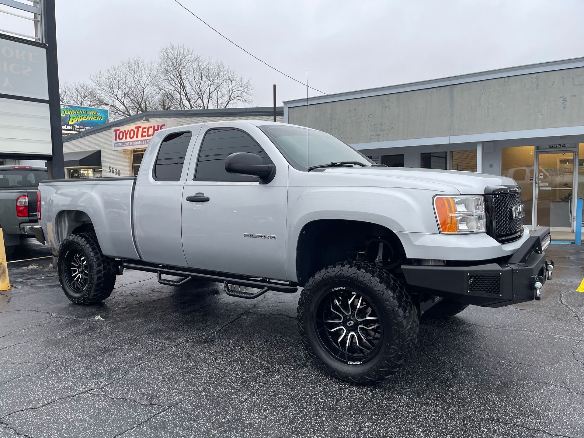 A white pickup truck is parked in front of a building.