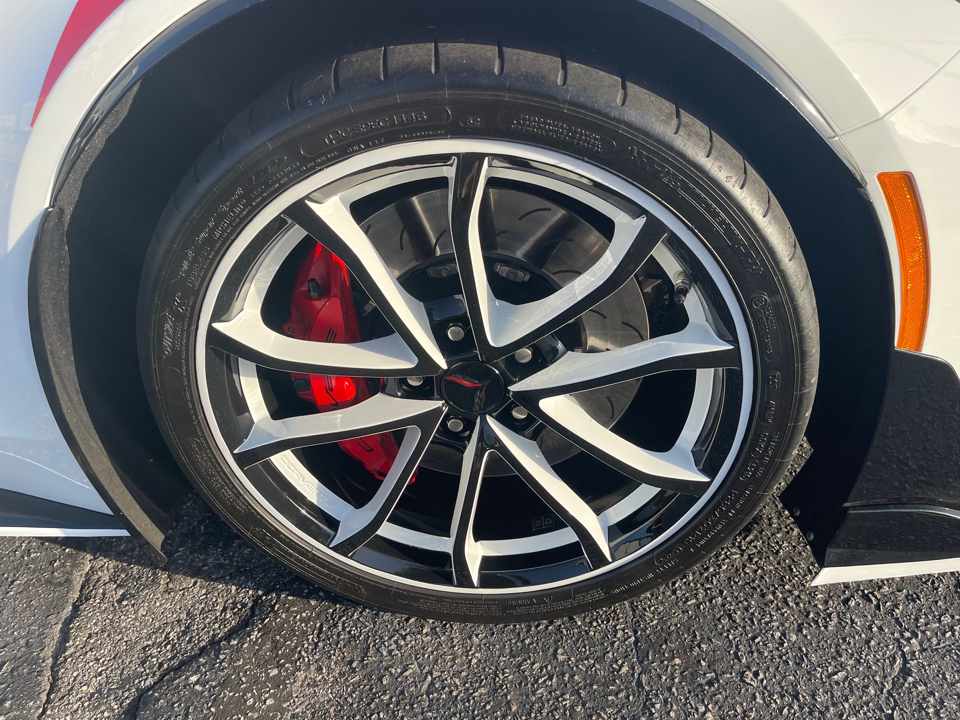 A close-up of a car wheel with red brake calipers