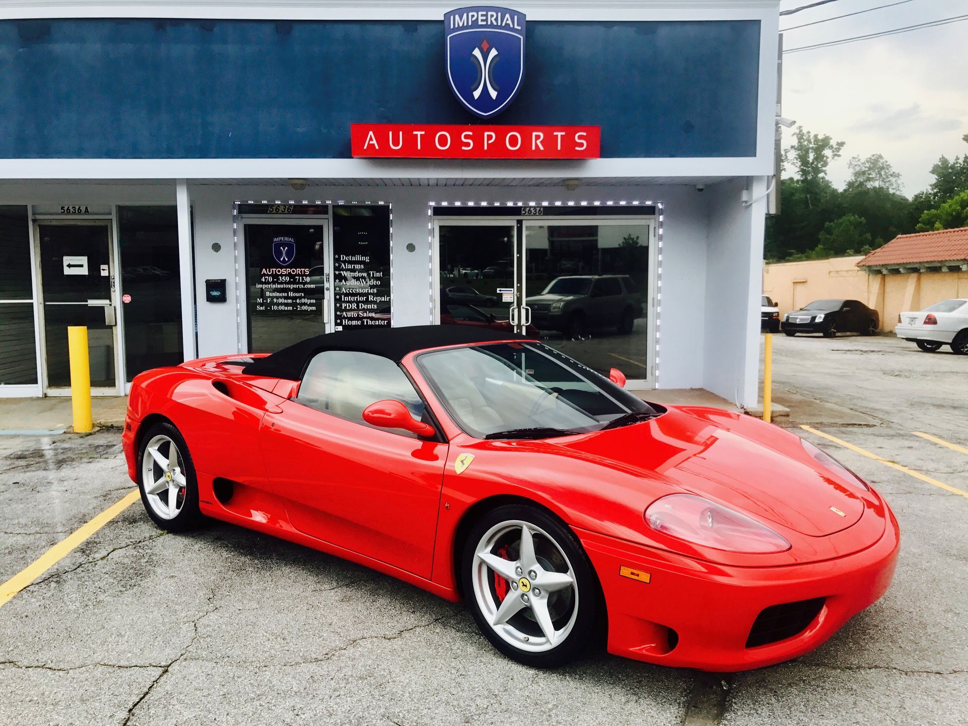 A red sports car is parked in front of a building